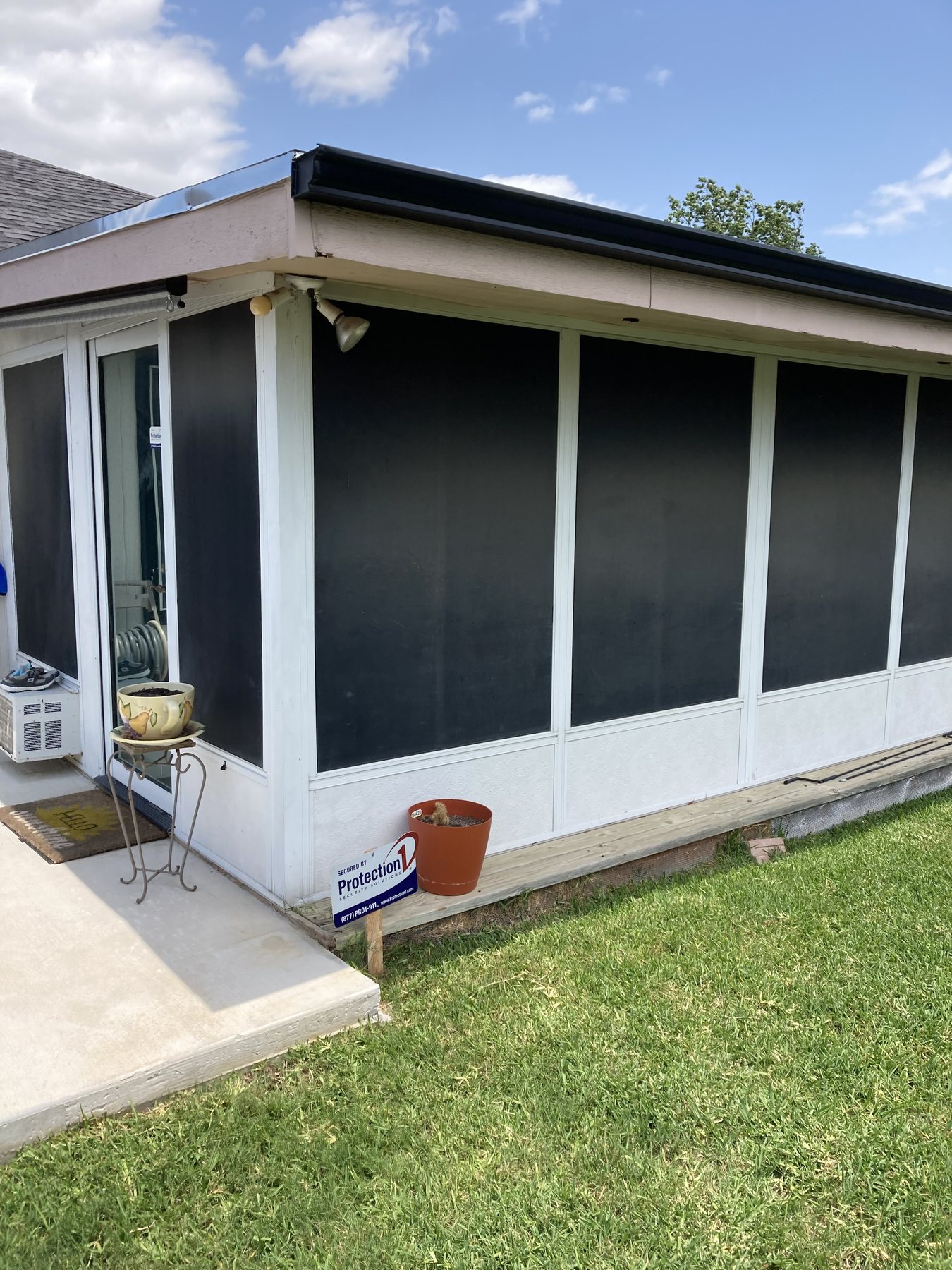 Completed screened porch exterior with dark screen panels and light trim