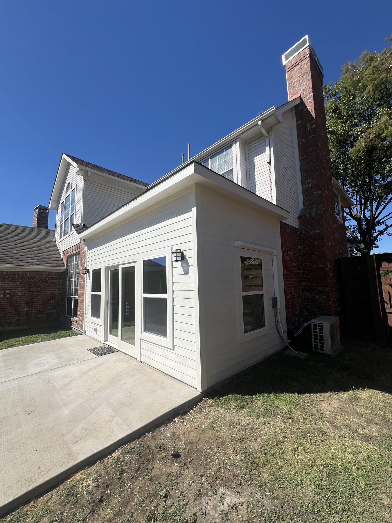 Finished side elevation of the sunroom addition with matching siding
