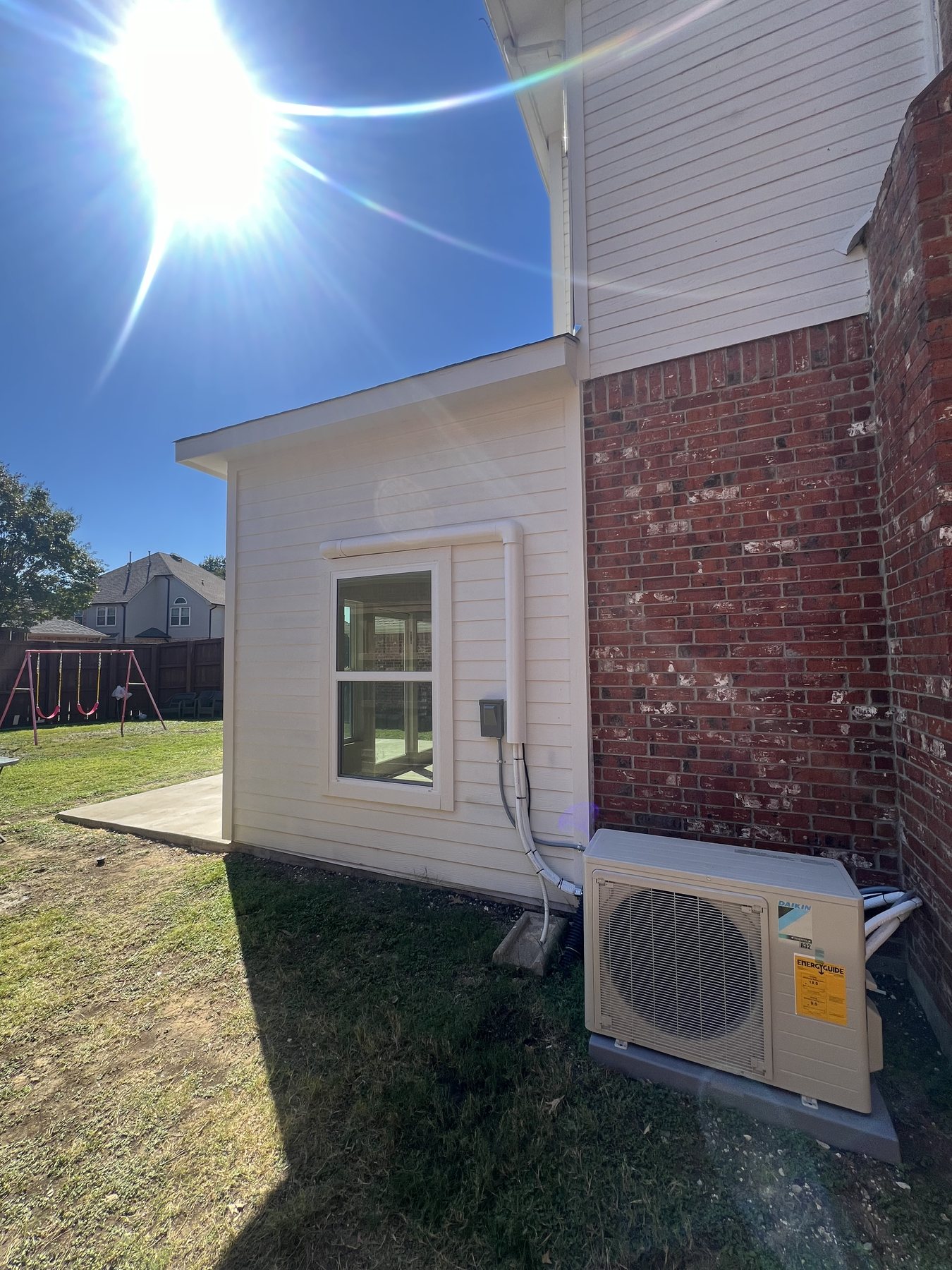 Finished sunroom addition with exterior mechanical equipment installed