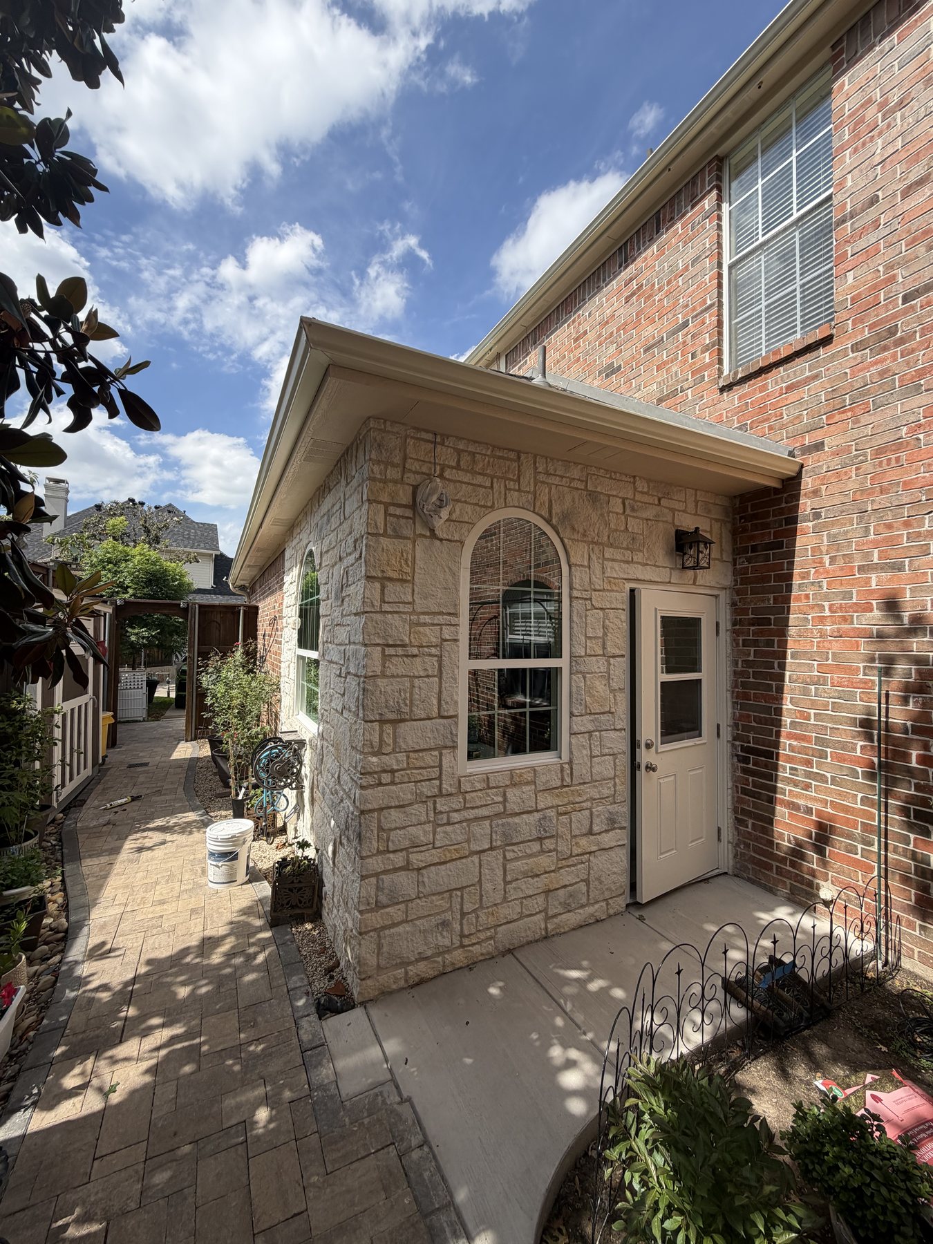 Completed side entry bumpout with stone exterior and covered roofline
