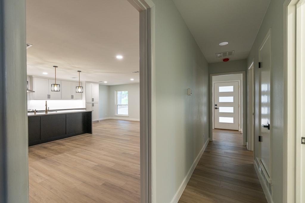 Updated hallway view opening into the renovated kitchen and living area
