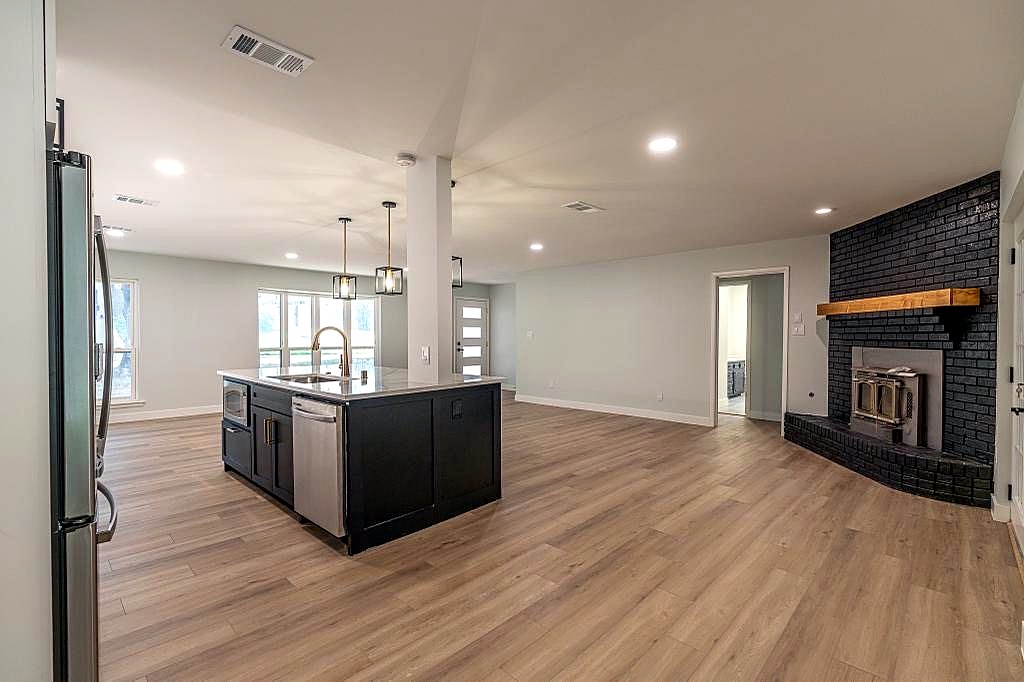 Open plan kitchen and living space with updated fireplace feature