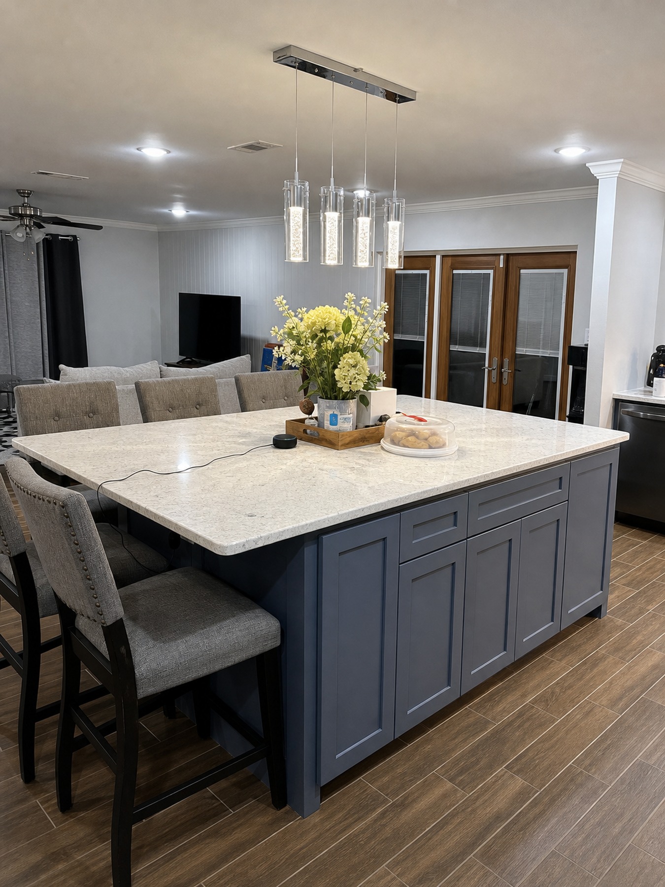 Kitchen island seating detail with blue gray cabinetry and stone countertop