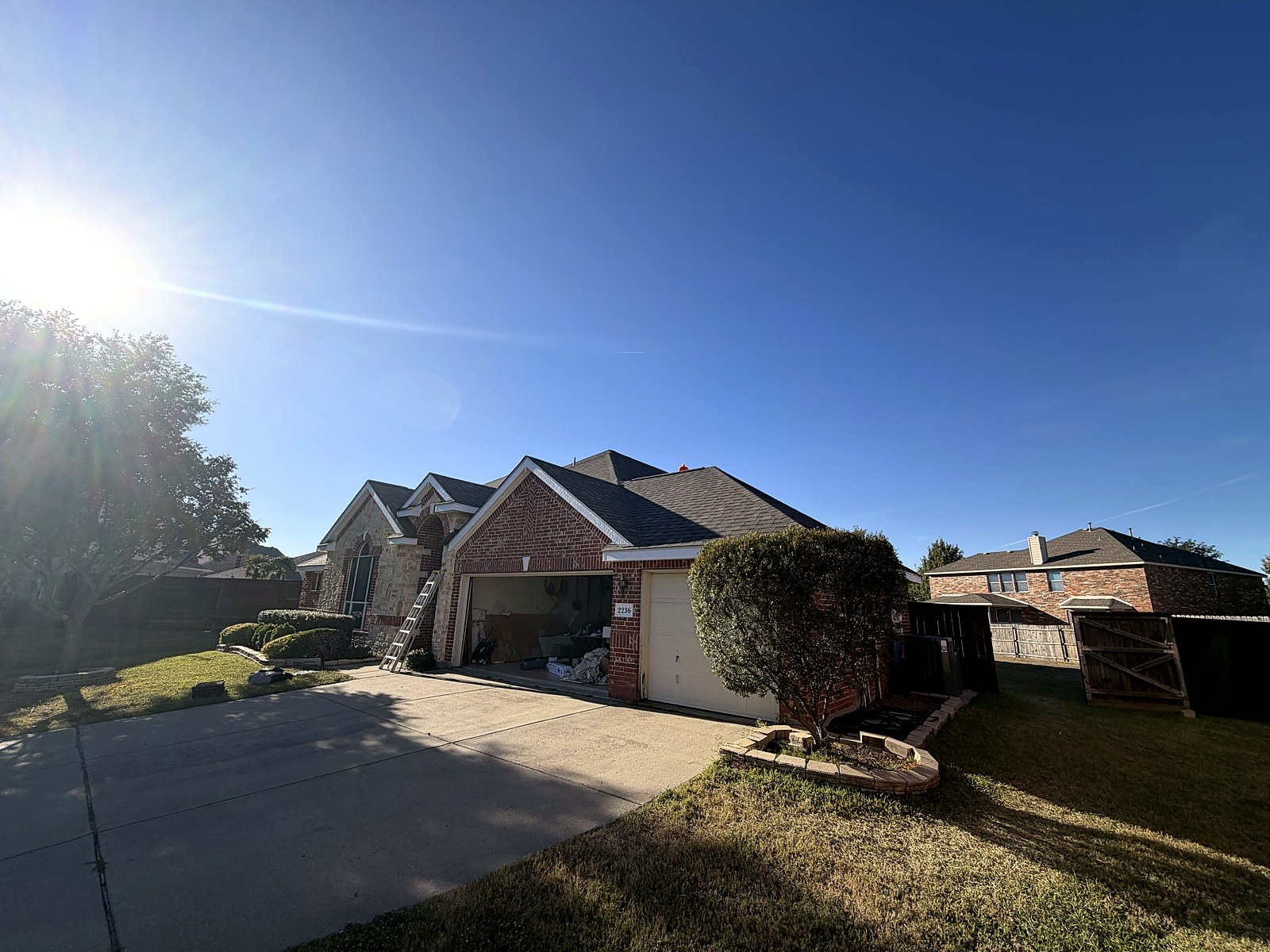 Finished residential roof replacement on a brick home, viewed from the front