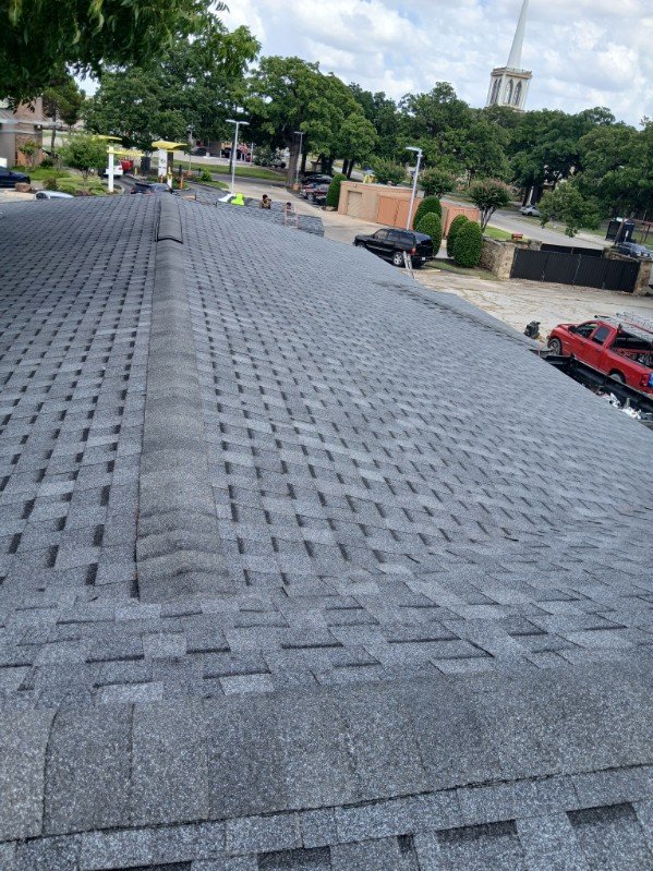 Wide finished roof with neighborhood church steeple visible in the background